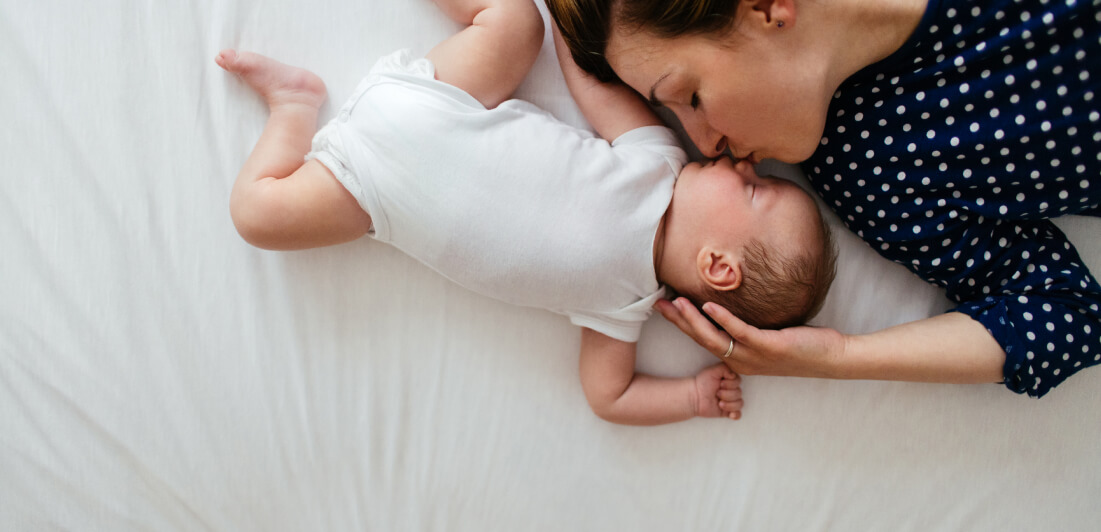 Mom kissing sleeping baby