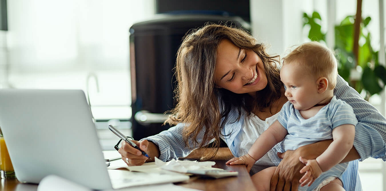 Mom doing taxes with her baby in her lap